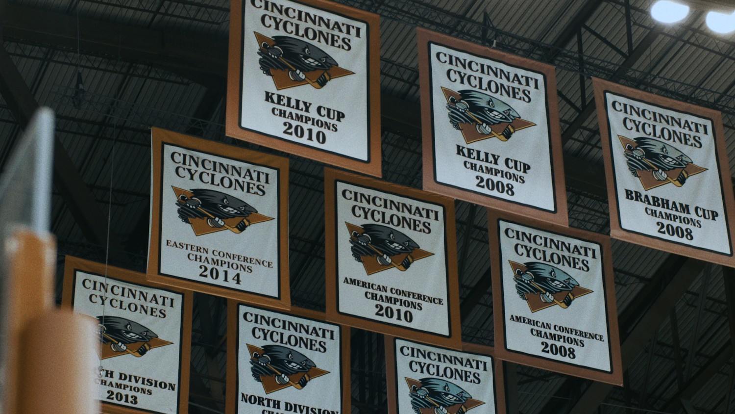 Shot of arena rafters. Nine banners are hung, celebrating various championships won by the Cincinnati Cyclones hockey team.